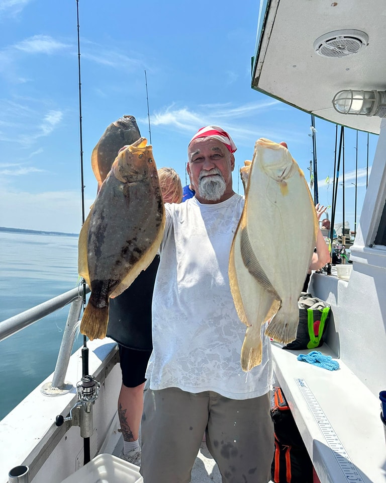 Angler with two large fluke on Celtic Quest charter boat