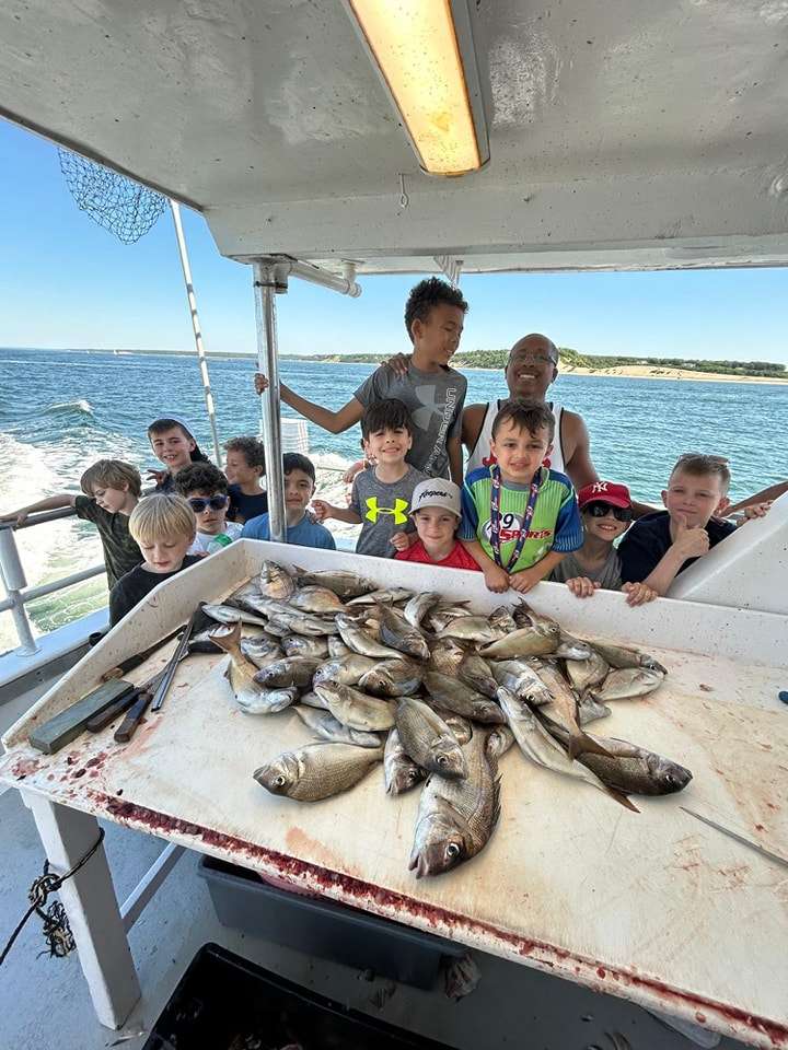 Kids showing off a table full of porgies aboard a Celtic Quest family fishing trip